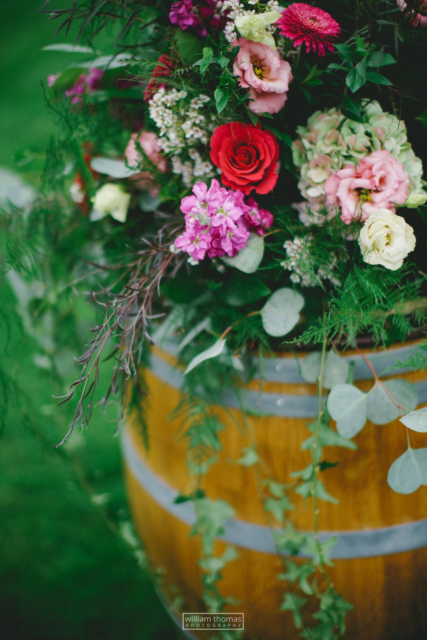 wedding floral arrangement on a rustic barrel for ceremony floral